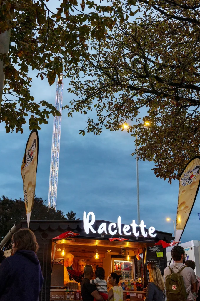 Raclette Event am Abend mit Gästen am Holz-Foodtruck